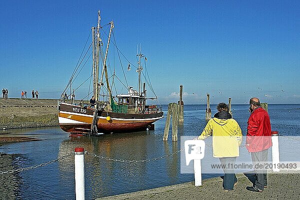 Fischerboot  Neuharlingersiel  bestaunt von 2 Touristen  Trockendock  Ostfriesland  Niedersachsen  Bundesrepublik Deutschland