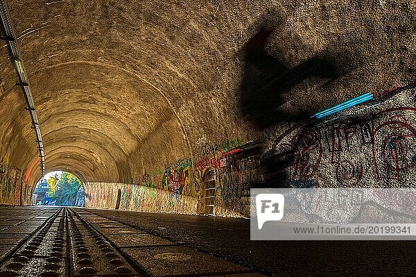 Unscharfer Radfahrer in einem Tunnel  dessen Wände mit buntem Graffiti bedeckt sind  Nordbahntrasse  Elberfeld  Wuppertal  Bergisches Land  Nordrhein-Westfalen