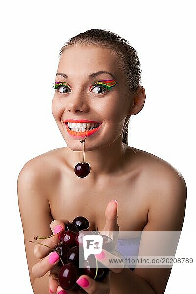 Lustige junge Frau essen eine von zwei reifen Kirschen isoliert