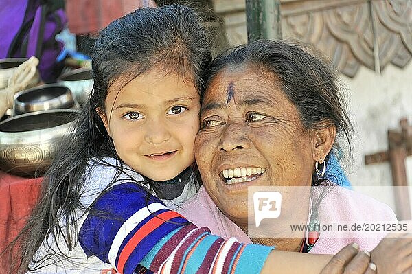 Eine Großmutter umarmt ihre Enkelin liebevoll und beide lächeln glücklich  Kathmandu-Tal  Kathmandu  Nepal  Asien