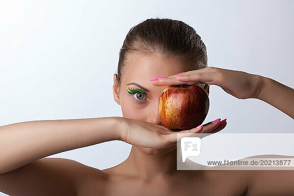 Schöne junge Frau mit rotem Apfel dicht halb Gesicht Porträt