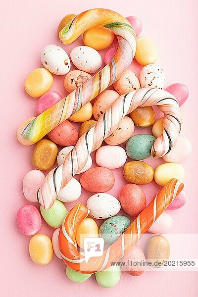 Various caramel candies on pink pastel background. close up  top view  flat lay