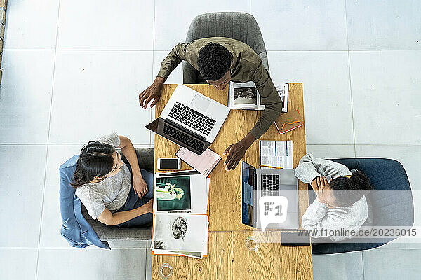 Advertising agency workers discussing project over laptop