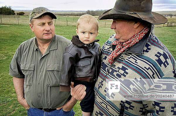 Three generations  a father  son and grandson spending time together on a ranch; Gibbon  Nebraska  United States of America