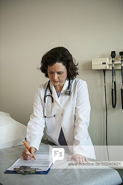 Physician's assistant studies paperwork in an empty patient room; Lincoln  Nebraska  United States of America