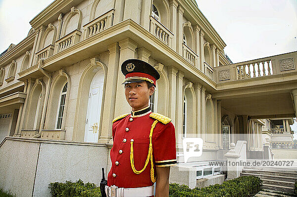 Red-uniformed guard stands outside a large villa in the Palais de Fortune development outside Beijing; People's Republic of China
