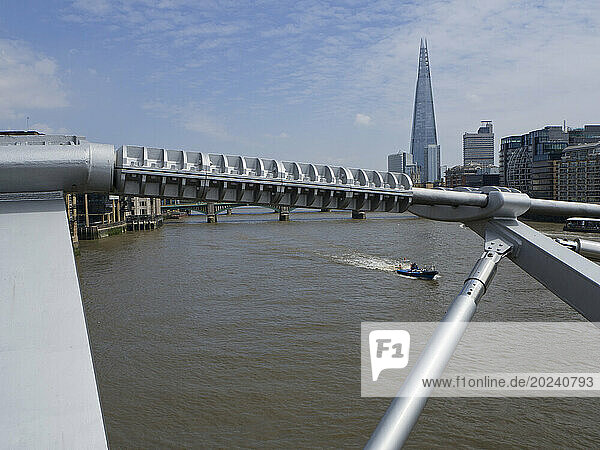 View of the Shard skyscraper and the south bank from the Millennium Bridge with speed boat passing; London  England