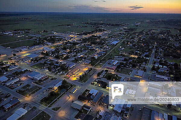 Aerial view of the town of Valentine  Nebraska after sunset with lights glowing on homes  businesses and empty streets; Valentine  Nebraska  United States of America