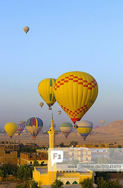 Hot air balloons carrying tourists over Luxor  Egypt; Luxor  Egypt