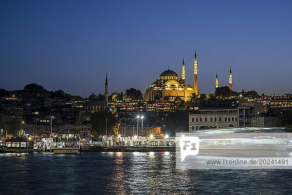 Suleymaniye Mosque and Bosphorus boats at night in Fatih district  Istanbul; Istanbul  Turkey