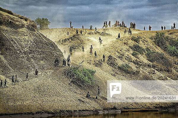 Kara tribe come racing over the hill from their village when they hear engine noise to greet one of the few boats on the Omo River; Kuchuru Village  Ethiopia
