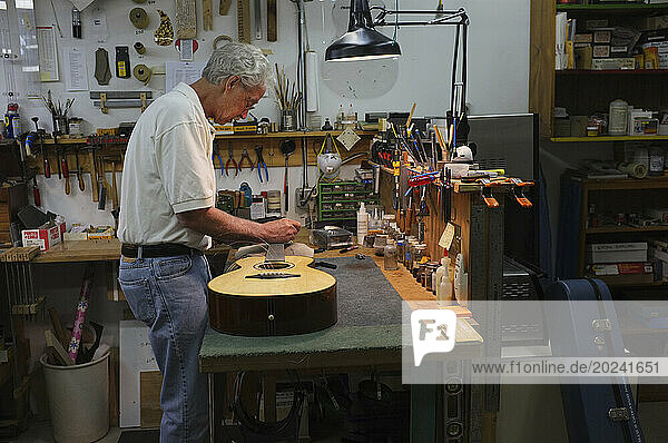 Guitarist working on a guitar in his shop