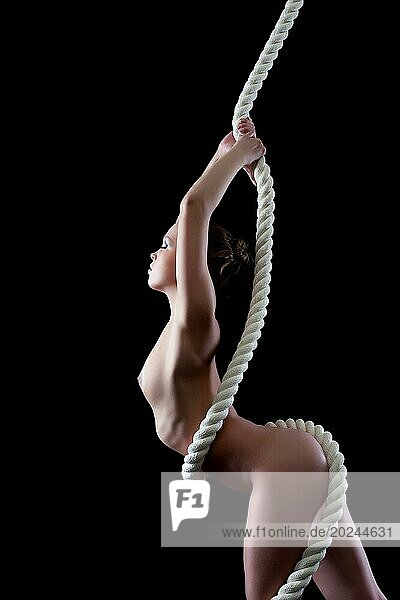 Profil einer schlanken nackten Frau mit Seil  vorSchwarz