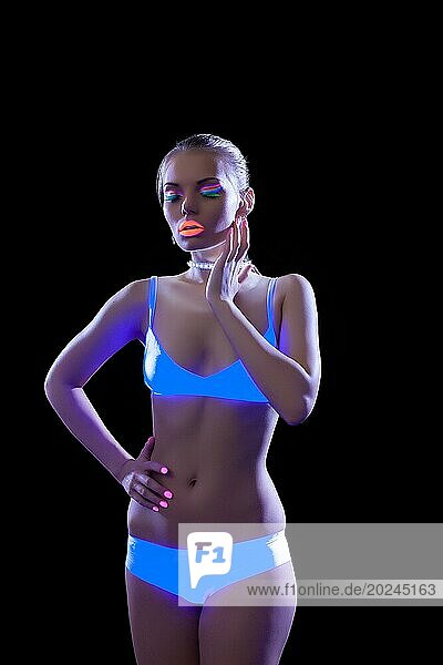 Verführerisches schlankes Mädchen posiert mit ultraviolettem Make up  vorSchwarz