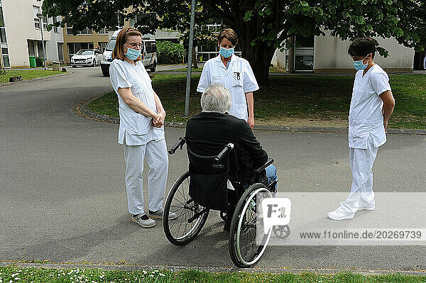 Patient discussing with medical staff outside a hospital.