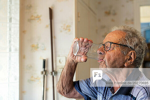 90 year old senior drinking thirstily.