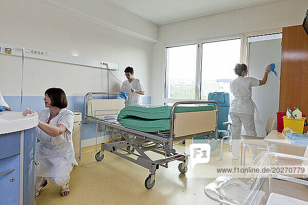 Childcare assistants cleaning a room after a patient leaves the diaper suite.