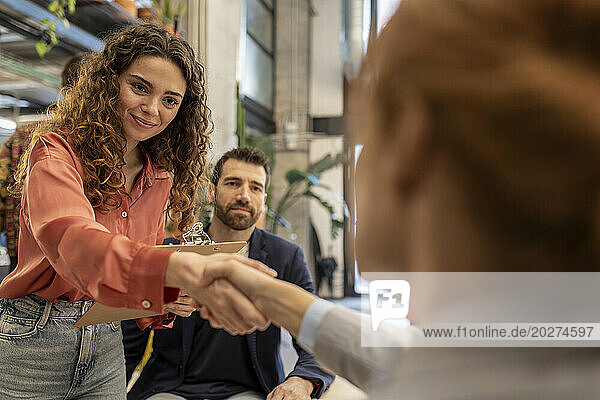 Smiling recruiter doing handshake with candidate at office