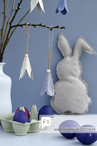 Studio shot of purple Easter eggs and DIY paper craft flowers