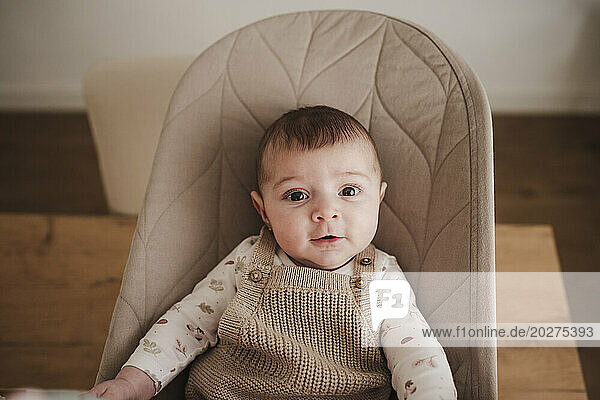 Smiling baby girl sitting on bouncer chair
