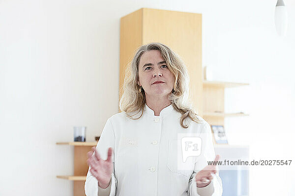 Thoughtful mature doctor standing at hospital
