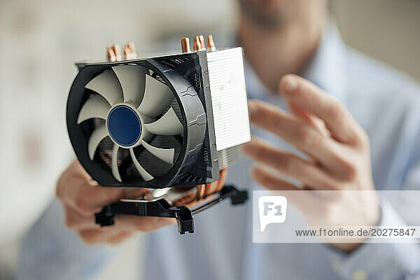 Engineer holding CPU fan at workshop