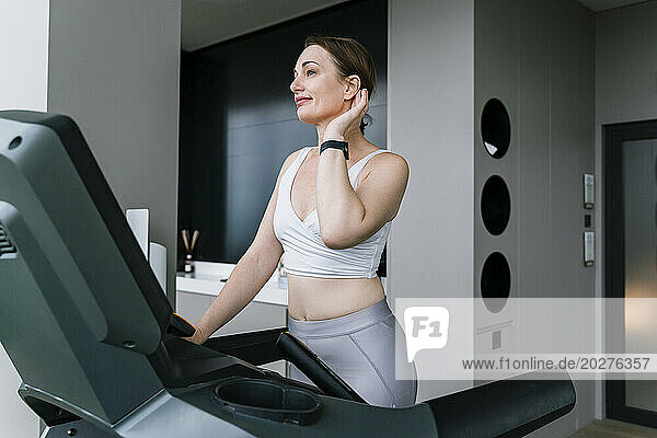 Mature woman doing cardio exercise on treadmill at gym