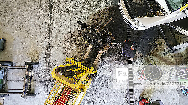 Mechanic working near forklift at workshop