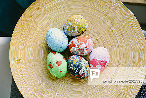 Multi colored Easter eggs in plate at home