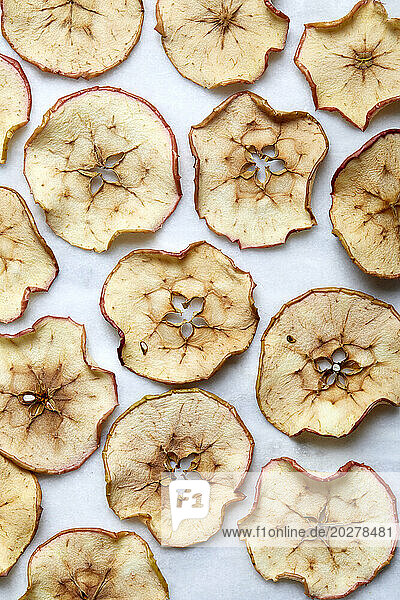 Overhead view of baked apple slices on white background