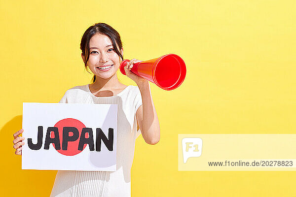 Japanese woman holding a sign with the word Japan and a megaphone