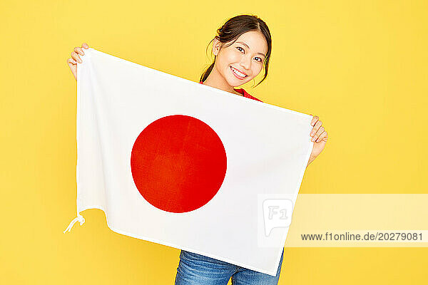 A woman holding up a Japanese flag