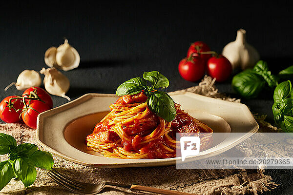 Spaghetti with tomato sauce and basil leaves on a plate
