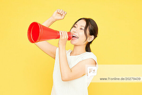Asian woman shouting into a megaphone