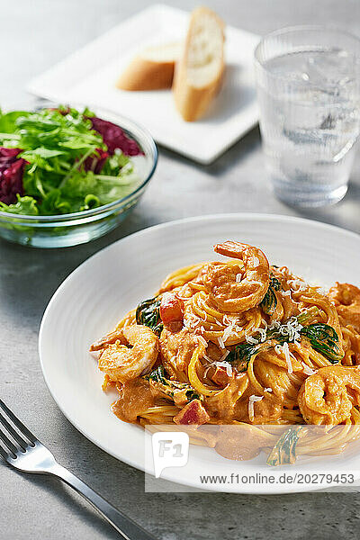 A plate of spaghetti with shrimp and spinach