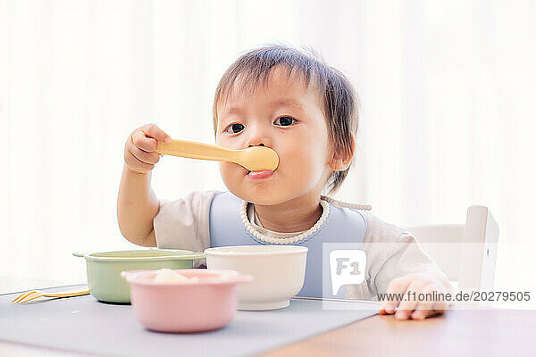 A baby eating a spoonful of food