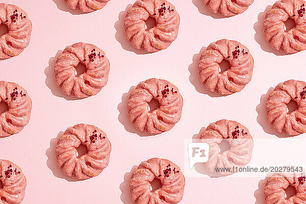 A pattern of donuts on a pink background