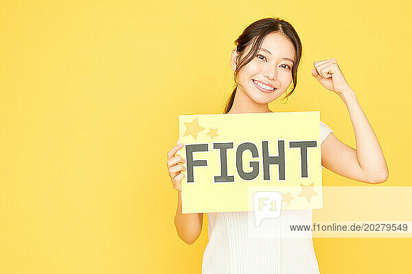 A woman holding up a sign that says fight