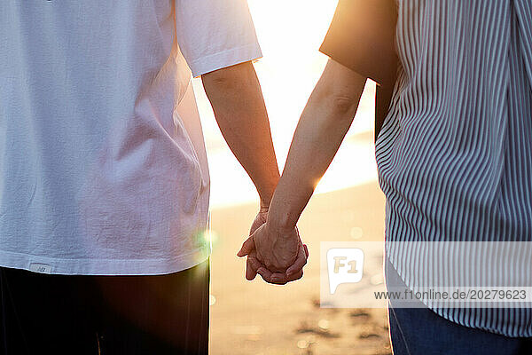 A couple holding hands on a beach