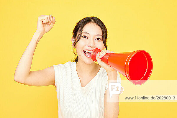 Asian woman holding a red megaphone