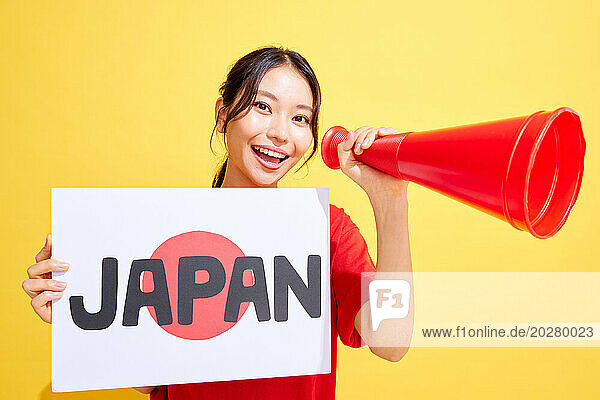 Japanese woman holding whiteboard and megaphone and cheering