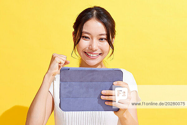 Asian woman holding a tablet computer