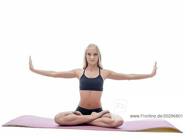 Bild der attraktiven schlanken Frau macht Yoga auf Matte im Studio