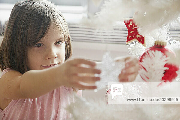 Close up of Young Girl Decorating Christmas Tree