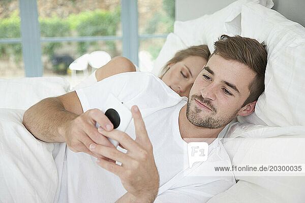 Man in Bed Using Smartphone