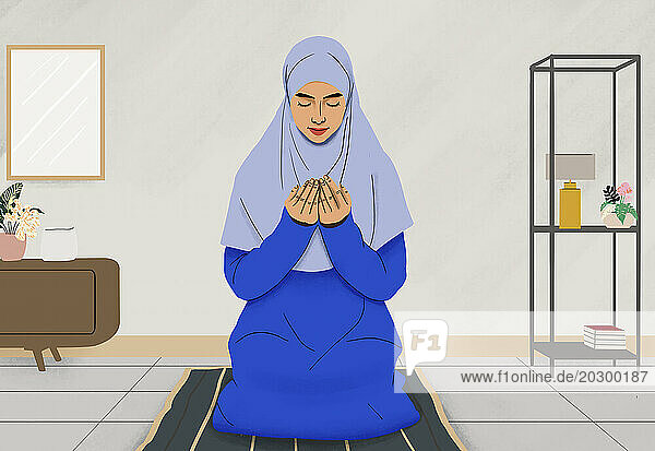 Muslim woman in hijab praying on mat at home