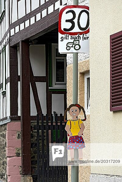 Verkehrsschild Tempo 30  auch für Traktor  Geschwindigkeitsbegrenzung  Mädchen  von Kindern gemalt  enge Gasse im Dorf  Nidda  Vogelsberg  Wetterau  Hessen  Deutschland  Europa