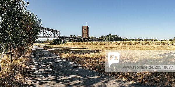 Duisburg  North Rhine-Westfalia  Germany  August 07  2018: A dried up meadow and cornfield after weeks without rain  with the Haus-Knipp Railway bridge and Zeche Rheinpreussen in the background  Europe