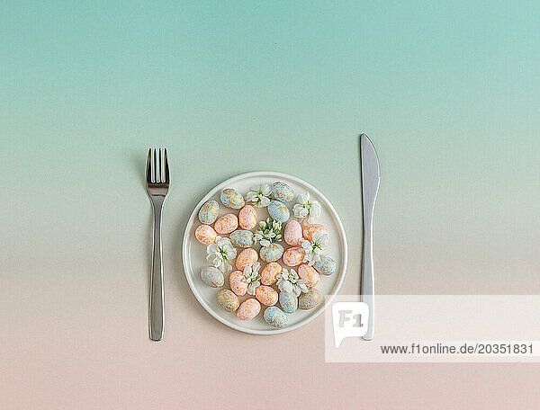 Pastel Easter Eggs on Plate with Utensils. Easter concept