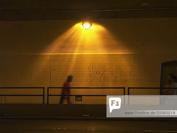 Shadow of man travelling in a pedestrian tunnel.